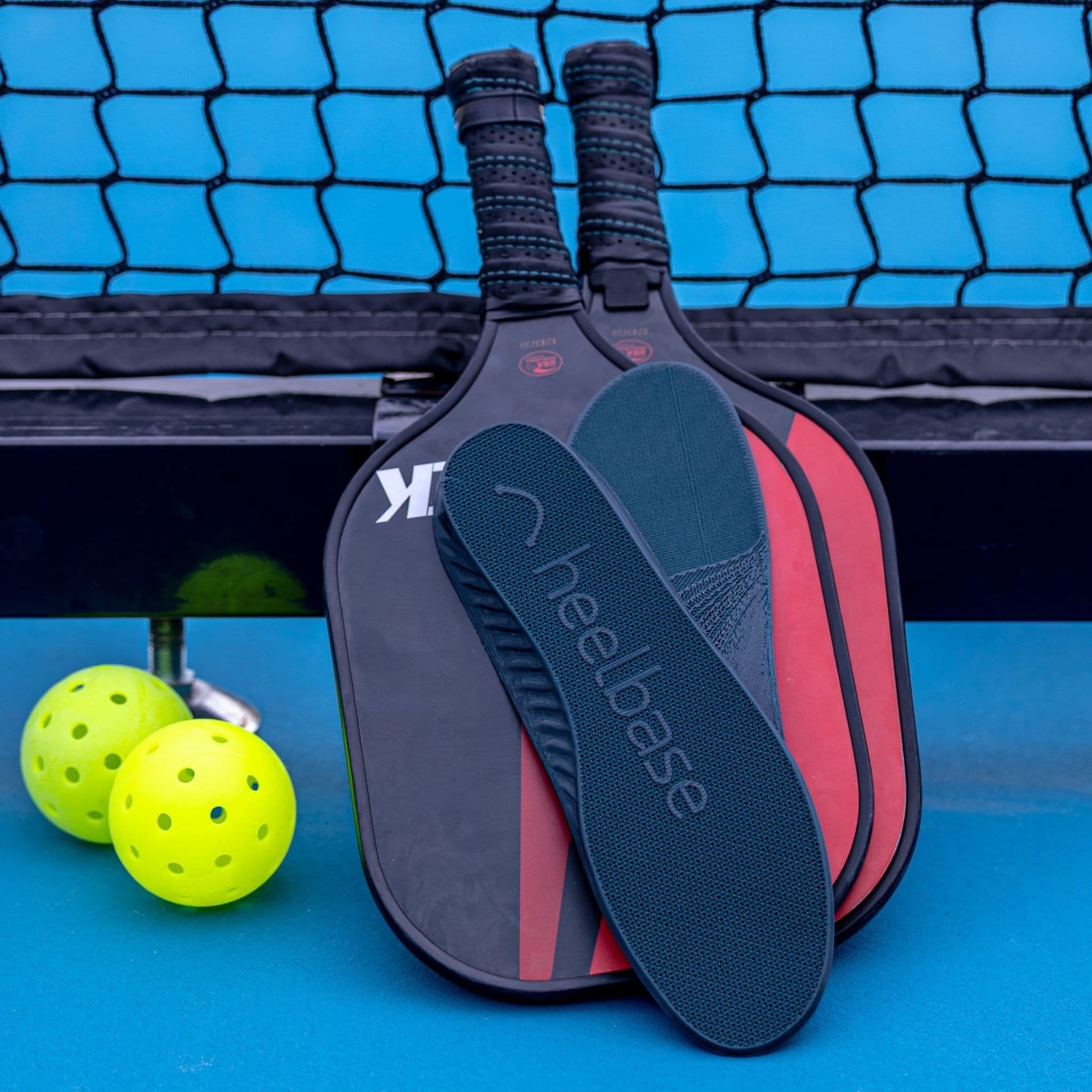HeelBase Drive insoles displayed with pickleball paddles and balls courtside
