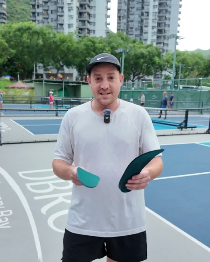 Alex M. holding HeelBase Drive insoles on a pickleball court