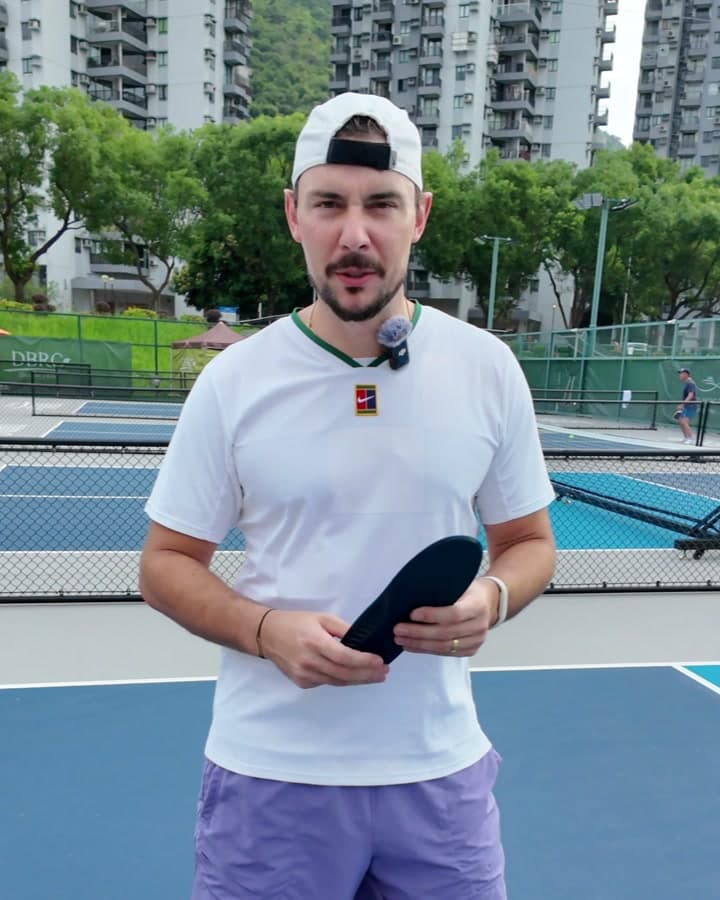 Daniel T. holding HeelBase Drive insoles on a pickleball court
