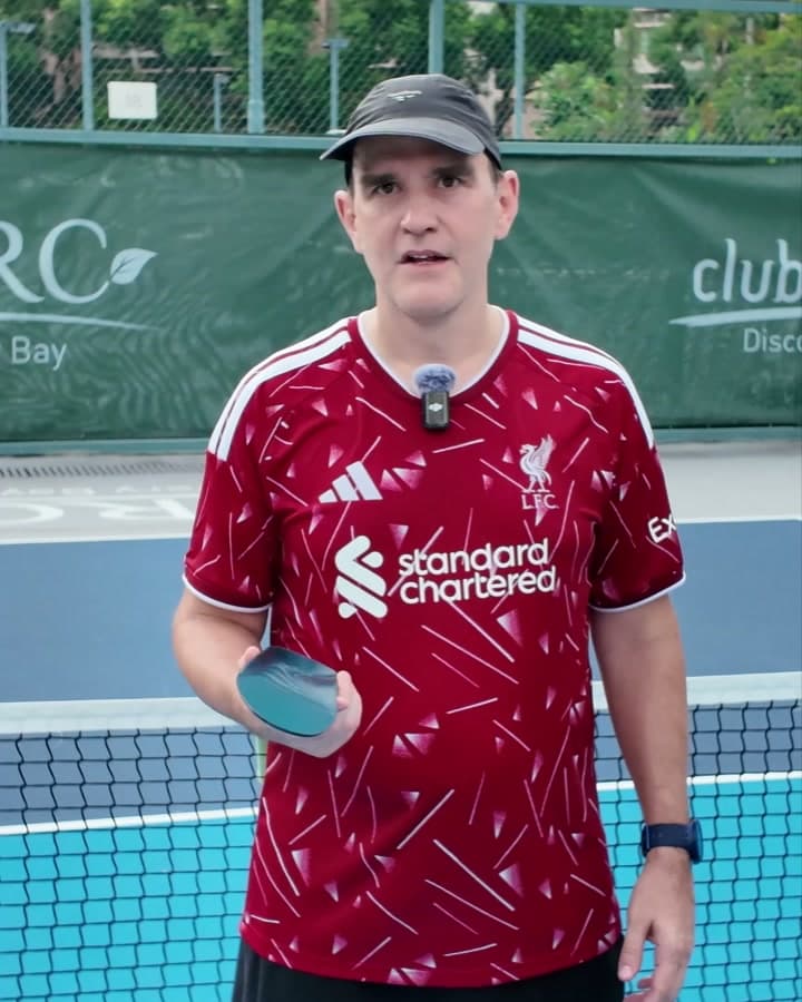 Tom L. holding HeelBase Drive insoles on a pickleball court