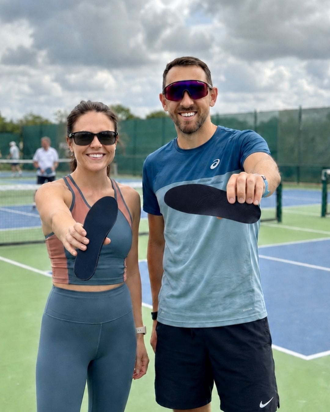 Hannah and Ollie holding HeelBase Drive insoles on a pickleball court