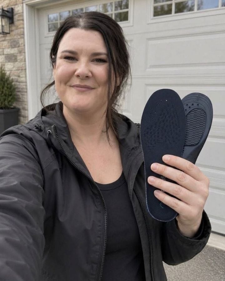 Jasmine holding a HeelBase Stance insole outdoors