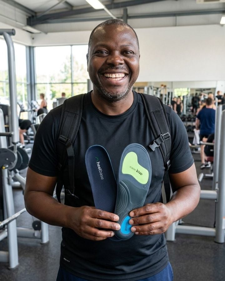 Lanre holding a pair of HeelBase Apex insoles